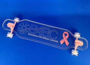 B4BC logo longboard with resin in a breast cancer awareness ribbon on it.