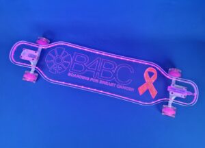 Clear longboard that lights up with LED lights with resin poured into it to make the breast cancer awareness ribbon for B4BC